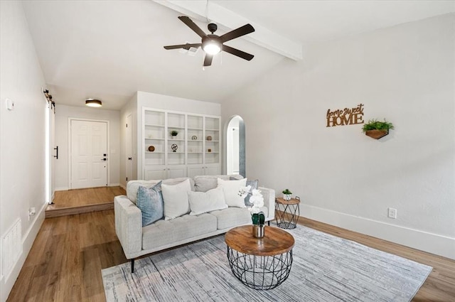 908 NW 12th St, Moore, OK 73160 - living area with arched walkways, wood finished floors, a ceiling fan, and a barn door