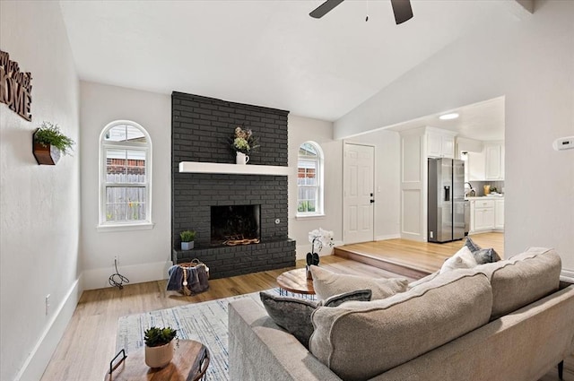 908 NW 12th St, Moore, OK 73160 - living room with ceiling fan, light wood-style floors, a brick fireplace, and lofted ceiling
