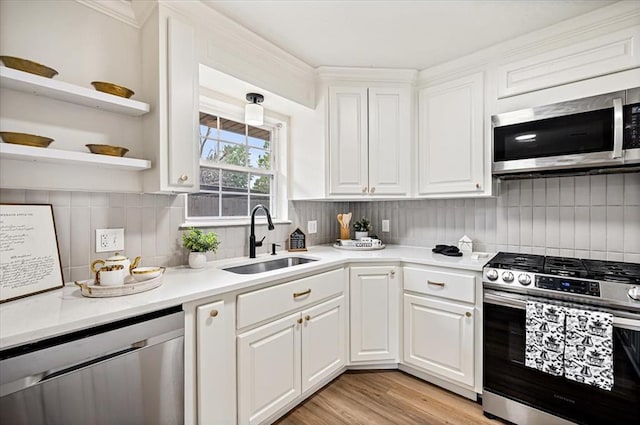 908 NW 12th St, Moore, OK 73160 - kitchen with appliances with stainless steel finishes, white cabinetry, light countertops, and tasteful backsplash