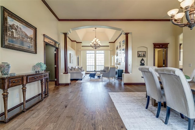 1704 NW 171st St, Edmond, OK 73012 - dining room featuring a chandelier, arched walkways, crown molding, ornate columns, and wood finished floors