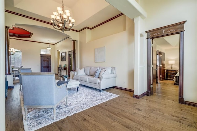 1704 NW 171st St, Edmond, OK 73012 - living area with a chandelier, arched walkways, crown molding, and wood finished floors