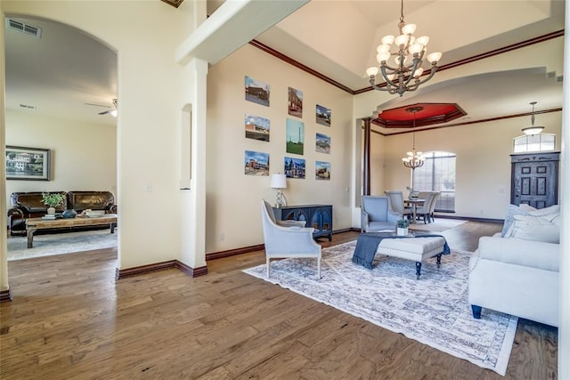 1704 NW 171st St, Edmond, OK 73012 - living room with a chandelier, wood finished floors, ornamental molding, arched walkways, and ceiling fan