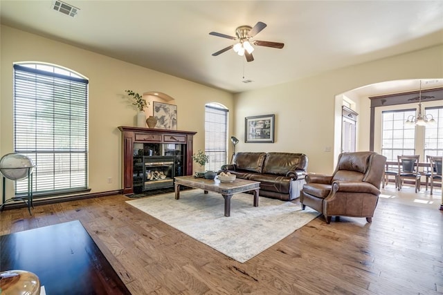 1704 NW 171st St, Edmond, OK 73012 - living area with a ceiling fan, arched walkways, wood finished floors, a chandelier, and a tiled fireplace