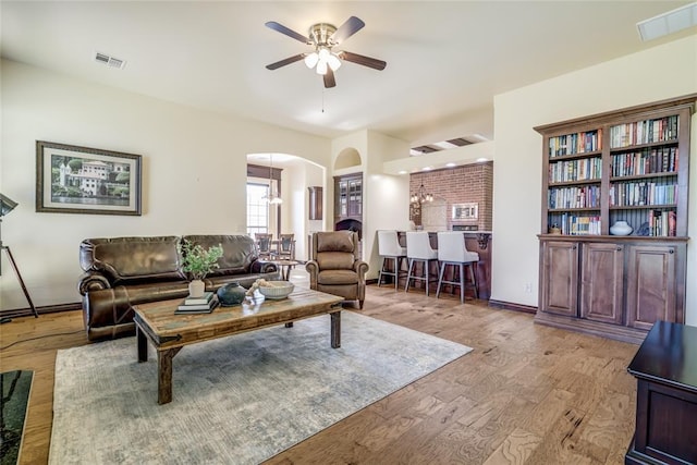 1704 NW 171st St, Edmond, OK 73012 - living area with arched walkways, ceiling fan, and wood finished floors