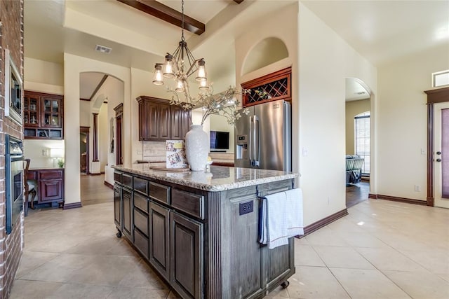 1704 NW 171st St, Edmond, OK 73012 - kitchen with stainless steel fridge, arched walkways, a towering ceiling, light tile patterned floors, and beamed ceiling