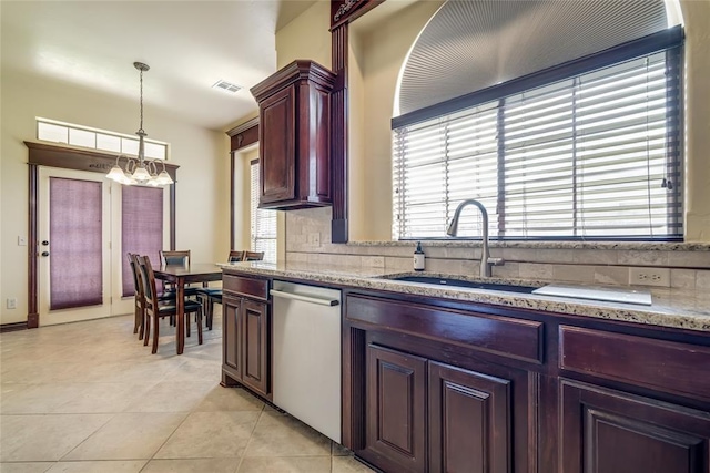 1704 NW 171st St, Edmond, OK 73012 - kitchen with stainless steel dishwasher, a chandelier, light tile patterned flooring, decorative light fixtures, and tasteful backsplash