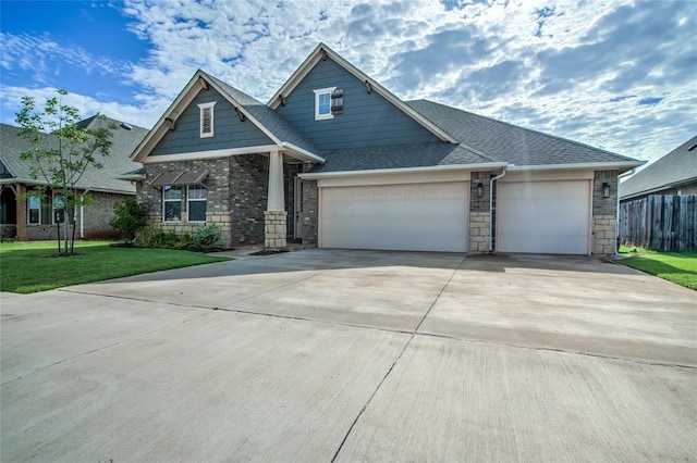 18445 Austin Pl, Edmond, OK 73012 - view of front of house featuring an attached garage, concrete driveway, stone siding, and roof with shingles
