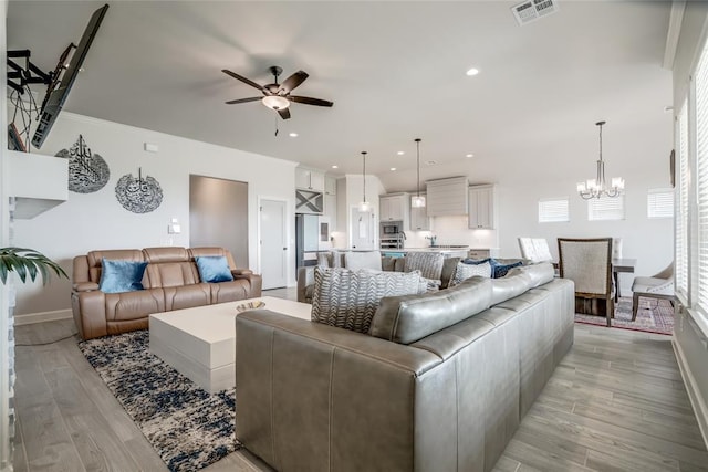 18445 Austin Pl, Edmond, OK 73012 - living room featuring ceiling fan, light wood-style flooring, a chandelier, and recessed lighting