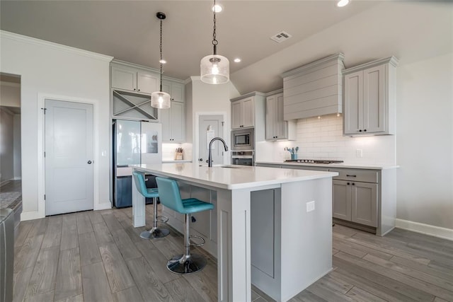 18445 Austin Pl, Edmond, OK 73012 - kitchen featuring appliances with stainless steel finishes, gray cabinetry, custom exhaust hood, light wood-type flooring, and recessed lighting