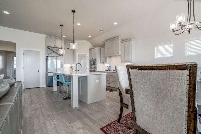 18445 Austin Pl, Edmond, OK 73012 - kitchen featuring a breakfast bar, a chandelier, light wood-type flooring, light countertops, and white refrigerator