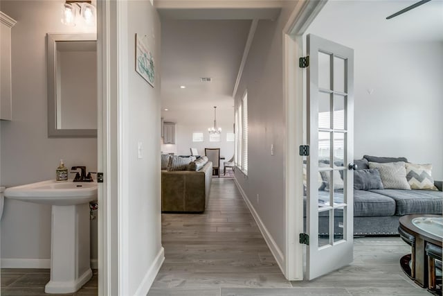 18445 Austin Pl, Edmond, OK 73012 - hallway with a chandelier and wood finished floors