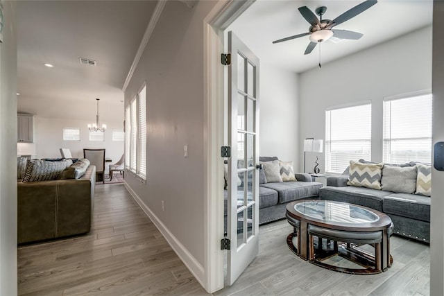 18445 Austin Pl, Edmond, OK 73012 - living area with light wood finished floors, a ceiling fan, and a chandelier