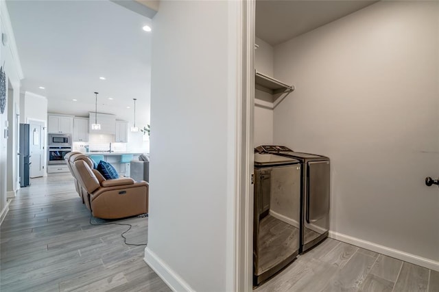 18445 Austin Pl, Edmond, OK 73012 - laundry room with independent washer and dryer, light wood-style floors, and recessed lighting