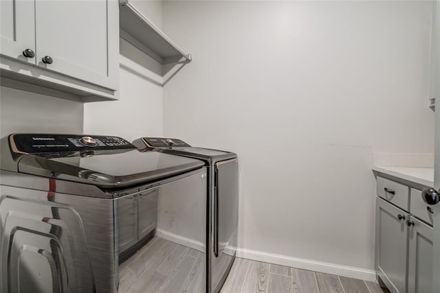 18445 Austin Pl, Edmond, OK 73012 - laundry room with washer and clothes dryer, cabinet space, and light wood-style floors