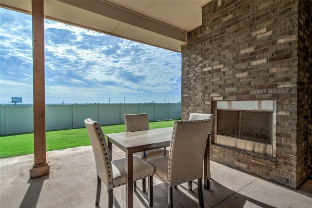 18445 Austin Pl, Edmond, OK 73012 - fenced backyard featuring an outdoor brick fireplace, a patio area, and outdoor dining space