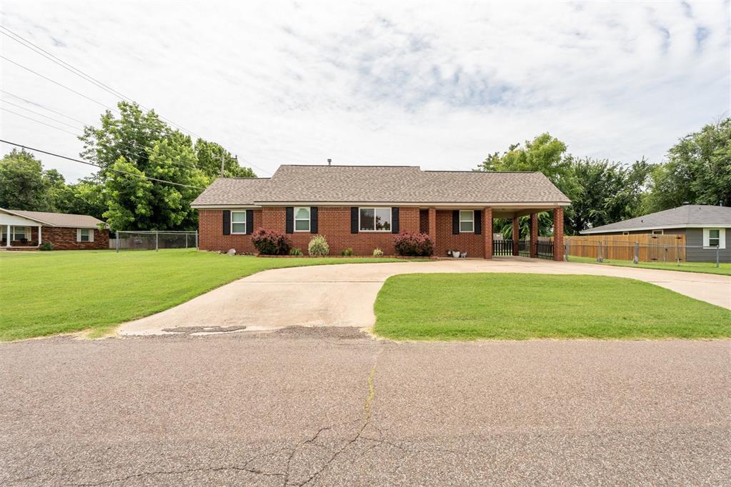 116 E Juniper Ln, Mustang, OK 73064 - ranch-style home with concrete driveway, brick siding, and an attached carport