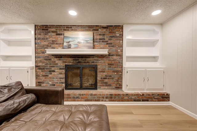 3725 N Grant Ave, Bethany, OK 73008 - living room featuring a textured ceiling, wood finished floors, built in shelves, a fireplace, and recessed lighting