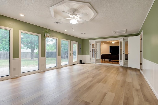 3725 N Grant Ave, Bethany, OK 73008 - unfurnished living room with a textured ceiling, ceiling fan, light wood finished floors, and wainscoting