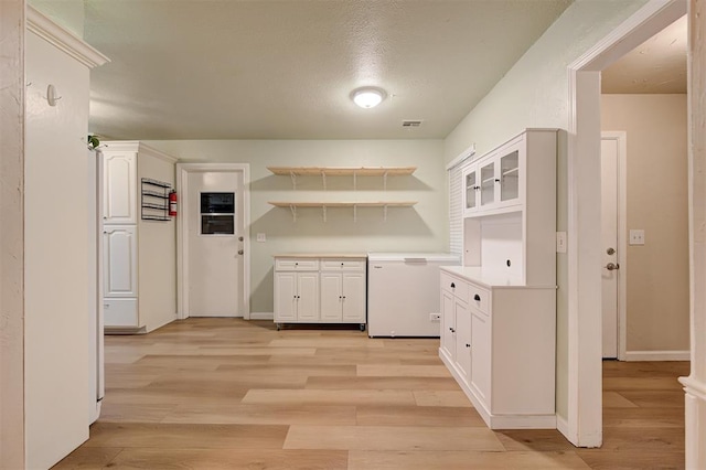 3725 N Grant Ave, Bethany, OK 73008 - kitchen featuring open shelves, white cabinetry, light wood-style flooring, light countertops, and glass insert cabinets