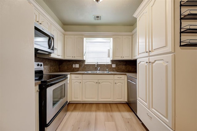 3725 N Grant Ave, Bethany, OK 73008 - kitchen featuring appliances with stainless steel finishes, light wood-style flooring, dark countertops, tasteful backsplash, and white cabinets