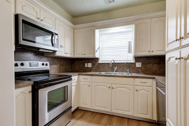 3725 N Grant Ave, Bethany, OK 73008 - kitchen featuring stainless steel appliances, dark countertops, tasteful backsplash, light wood-type flooring, and white cabinetry