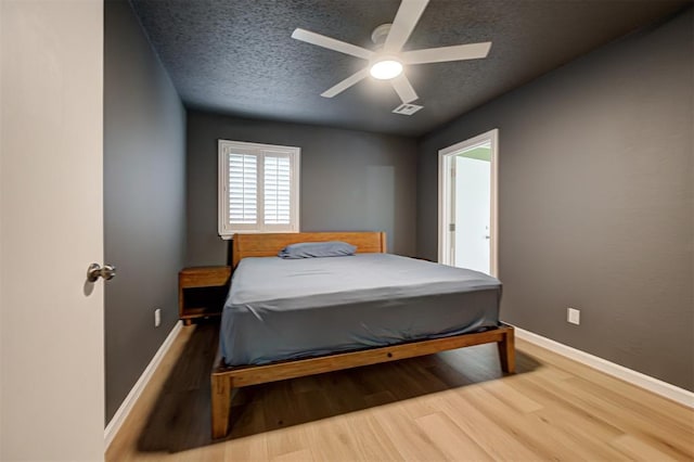 3725 N Grant Ave, Bethany, OK 73008 - bedroom with wood finished floors, a textured ceiling, and a ceiling fan