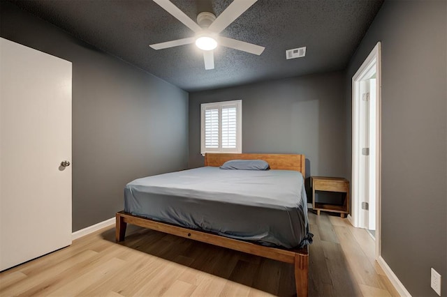 3725 N Grant Ave, Bethany, OK 73008 - bedroom with a textured ceiling, light wood finished floors, and a ceiling fan