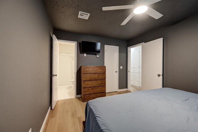 3725 N Grant Ave, Bethany, OK 73008 - bedroom featuring light wood-style flooring, connected bathroom, ceiling fan, and a textured ceiling