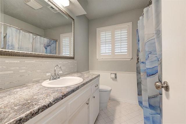 3725 N Grant Ave, Bethany, OK 73008 - bathroom featuring vanity, backsplash, tile patterned floors, and wainscoting