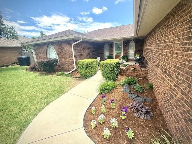 2608 SW 93rd, Oklahoma City, OK 73159 - view of exterior entry with brick siding, a yard, and a shingled roof