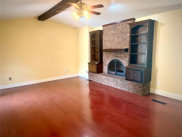2608 SW 93rd, Oklahoma City, OK 73159 - unfurnished living room with ceiling fan, dark wood-style floors, a large fireplace, and a textured ceiling