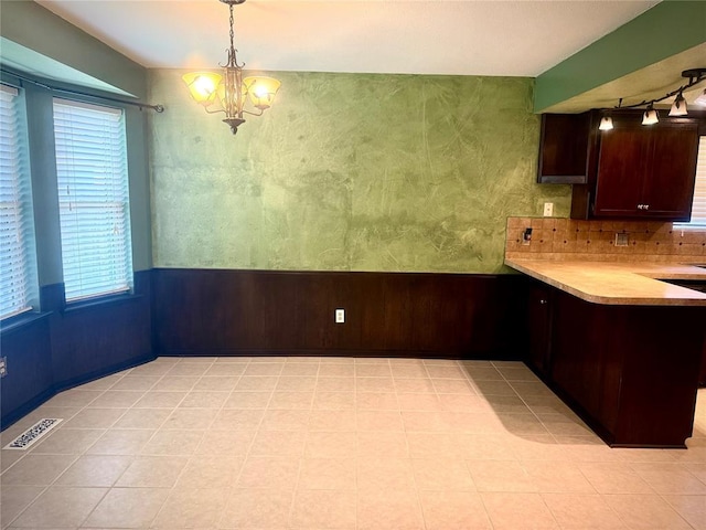 2608 SW 93rd, Oklahoma City, OK 73159 - kitchen featuring a chandelier, light countertops, a peninsula, pendant lighting, and decorative backsplash