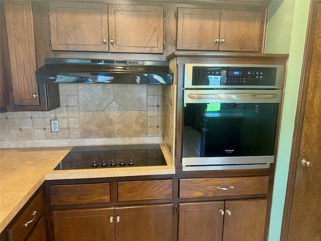 2608 SW 93rd, Oklahoma City, OK 73159 - kitchen with oven, black electric cooktop, exhaust hood, and decorative backsplash