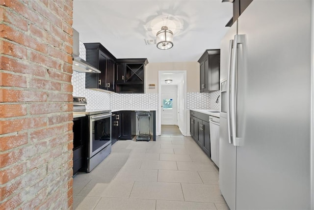 536 NW 48th St, Oklahoma City, OK 73118 - kitchen with appliances with stainless steel finishes, wall chimney range hood, light countertops, tasteful backsplash, and open shelves