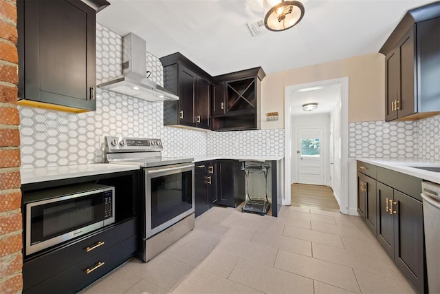 536 NW 48th St, Oklahoma City, OK 73118 - kitchen with stainless steel appliances, light countertops, wall chimney exhaust hood, and decorative backsplash