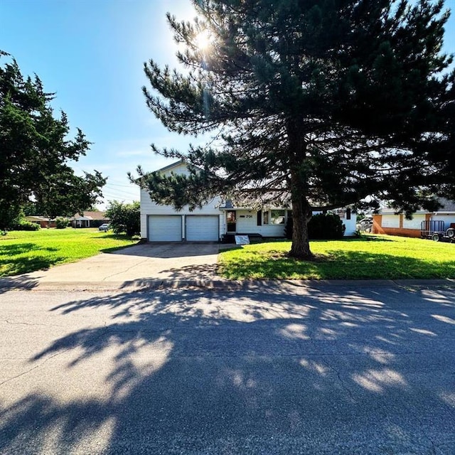701 S 18th St, Clinton, OK 73601 - obstructed view of property featuring concrete driveway, a front lawn, and an attached garage