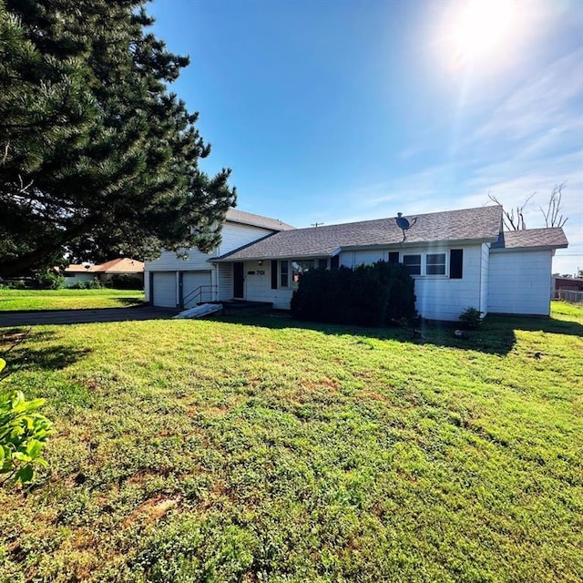 701 S 18th St, Clinton, OK 73601 - rear view of property featuring asphalt driveway, an attached garage, and a yard