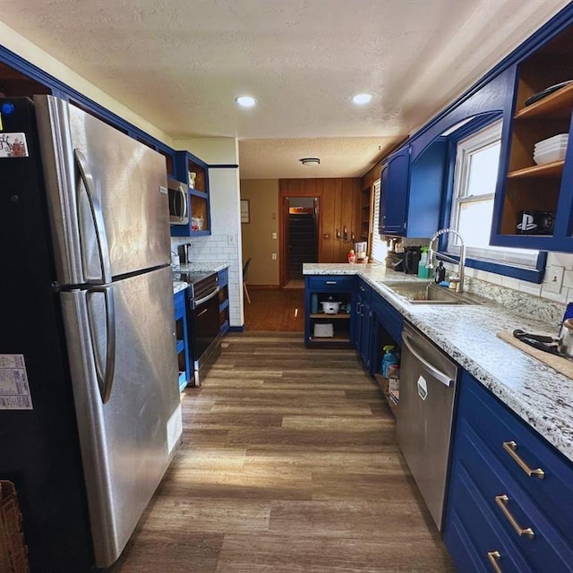 701 S 18th St, Clinton, OK 73601 - kitchen featuring blue cabinets, appliances with stainless steel finishes, open shelves, light countertops, and dark wood-type flooring