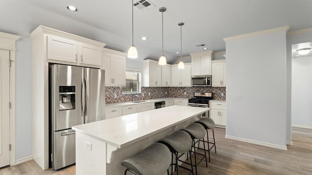 3021 NW 179th Ct, Edmond, OK 73012 - kitchen featuring stainless steel appliances, a kitchen breakfast bar, decorative backsplash, light countertops, and recessed lighting