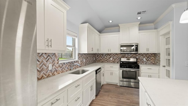 3021 NW 179th Ct, Edmond, OK 73012 - kitchen featuring appliances with stainless steel finishes, recessed lighting, decorative backsplash, white cabinets, and wood finished floors