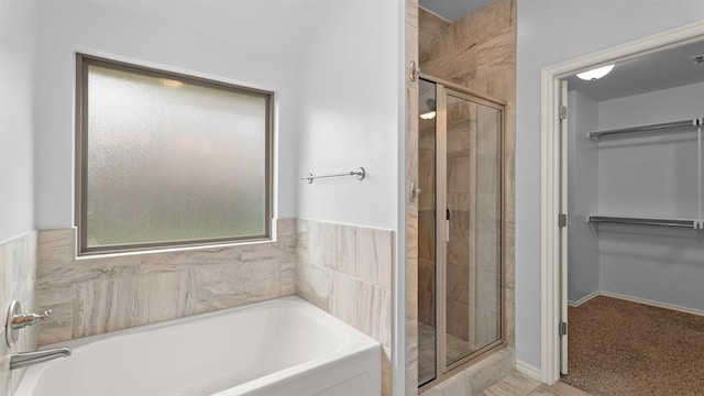3021 NW 179th Ct, Edmond, OK 73012 - full bath featuring a stall shower, a bath, a spacious closet, and plenty of natural light