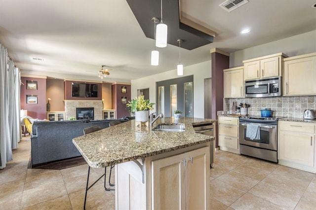 17425 White Hawk Dr, Edmond, OK 73012 - kitchen with appliances with stainless steel finishes, tasteful backsplash, ceiling fan, and light stone countertops