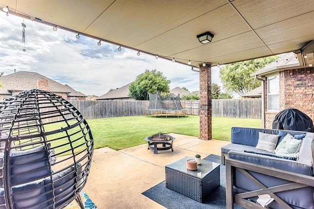 17425 White Hawk Dr, Edmond, OK 73012 - fenced backyard with a patio, a trampoline, and an outdoor living space with a fire pit