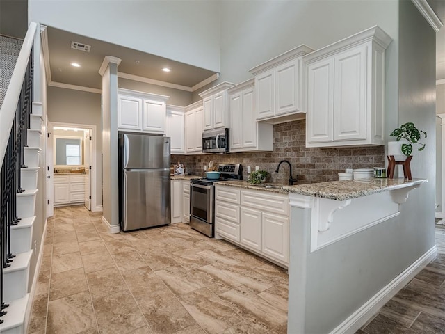 4800 Stelens Ct, Norman, OK 73071 - kitchen with stainless steel appliances, ornamental molding, white cabinetry, decorative backsplash, and light stone countertops