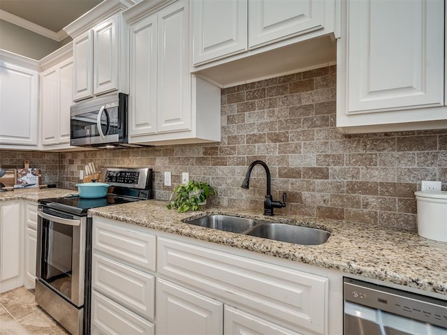 4800 Stelens Ct, Norman, OK 73071 - kitchen featuring appliances with stainless steel finishes, white cabinets, ornamental molding, backsplash, and light stone counters