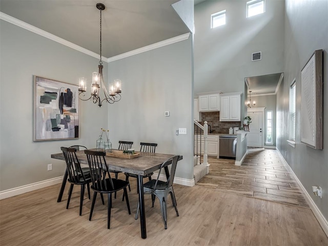 4800 Stelens Ct, Norman, OK 73071 - dining space with a chandelier, light wood-style flooring, a high ceiling, stairs, and ornamental molding