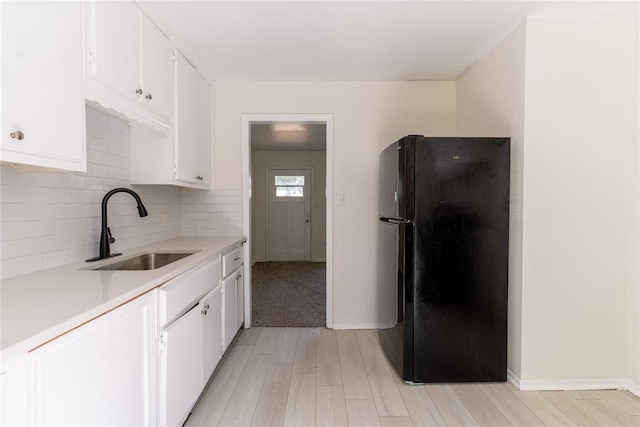 3820 SE 23rd St, Del City, OK 73115 - kitchen featuring freestanding refrigerator, light wood finished floors, light countertops, white cabinetry, and decorative backsplash