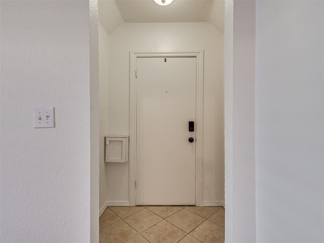 500 Dakota St, Norman, OK 73069 - doorway to outside featuring light tile patterned flooring, vaulted ceiling, a textured ceiling, and a textured wall