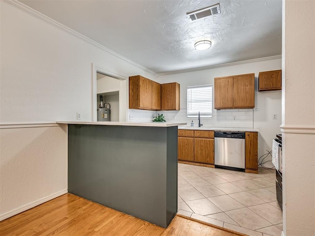 500 Dakota St, Norman, OK 73069 - kitchen with stainless steel dishwasher, brown cabinetry, light countertops, ornamental molding, and backsplash