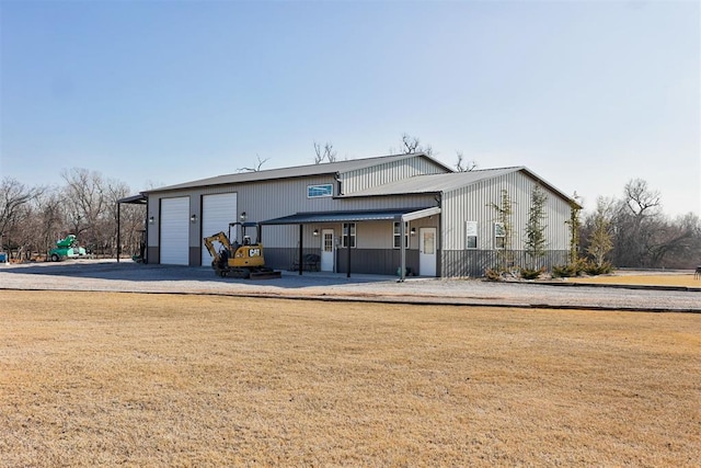 8960 N Banner Rd, Yukon, OK 73099 - rear view of property with driveway, a garage, and a lawn